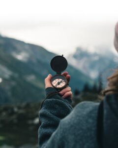 a person wearing black jacket holding a compass