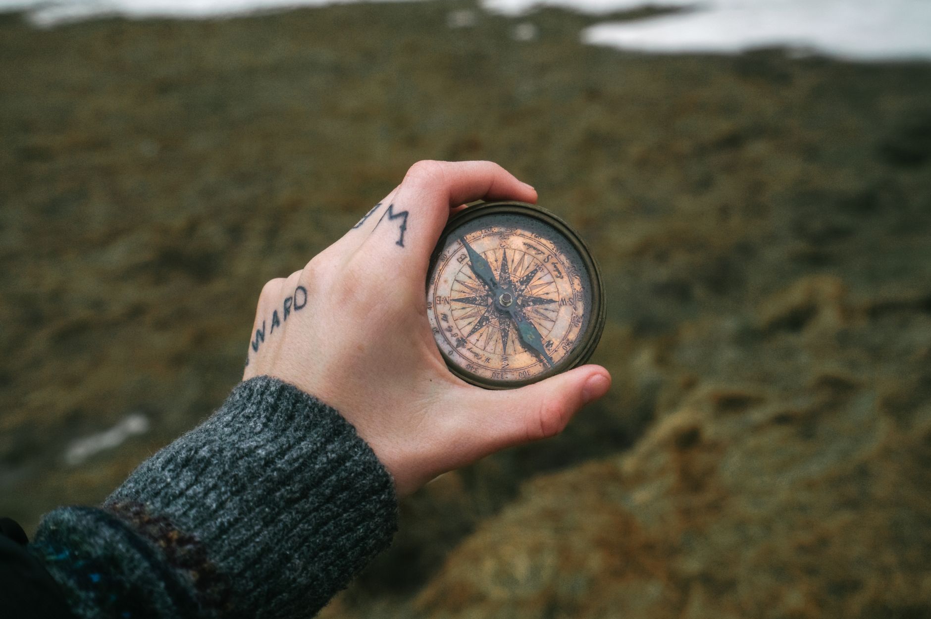 close up of hand holding compass